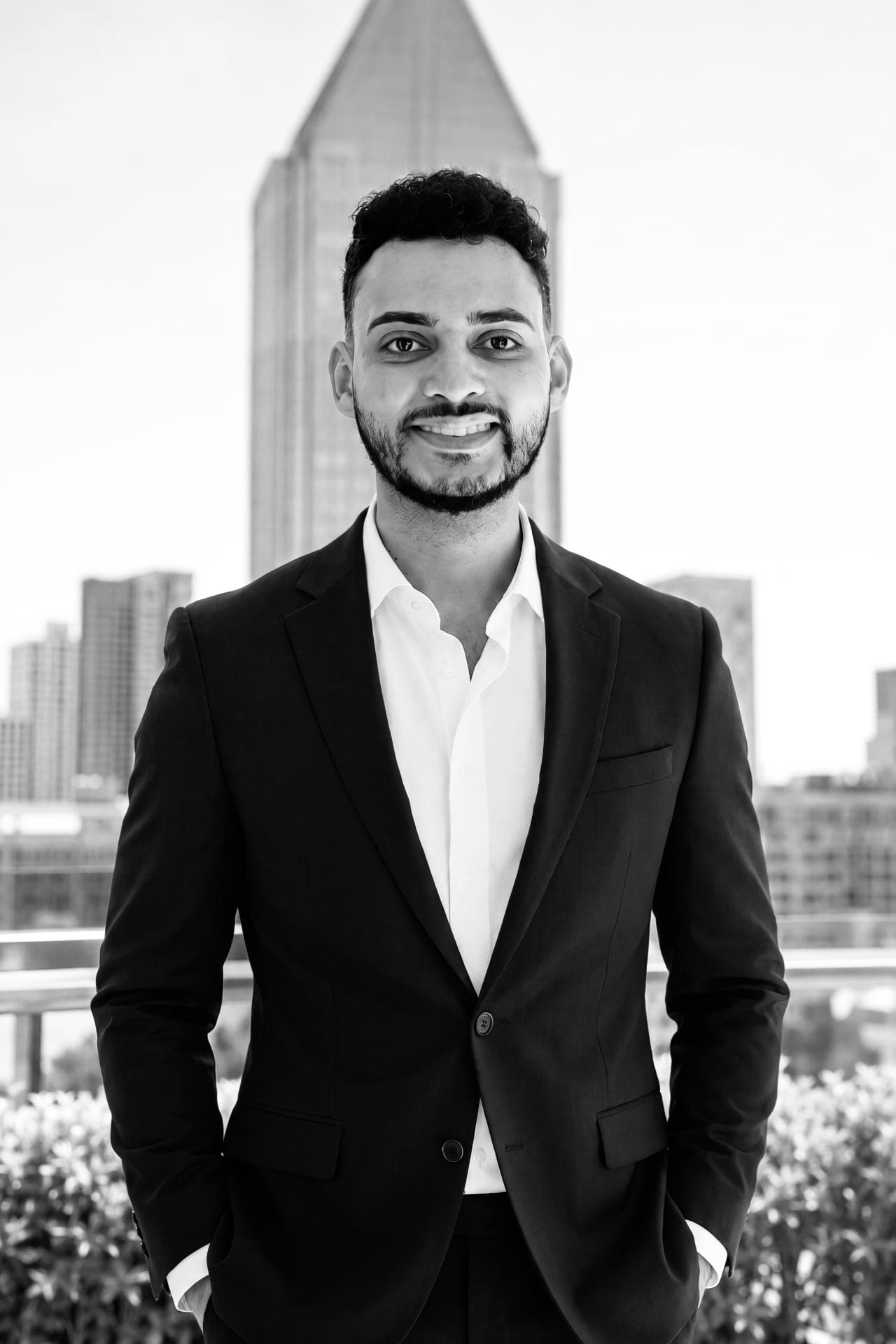 Henrique Rodrigues, black-and-white portrait against a city skyline